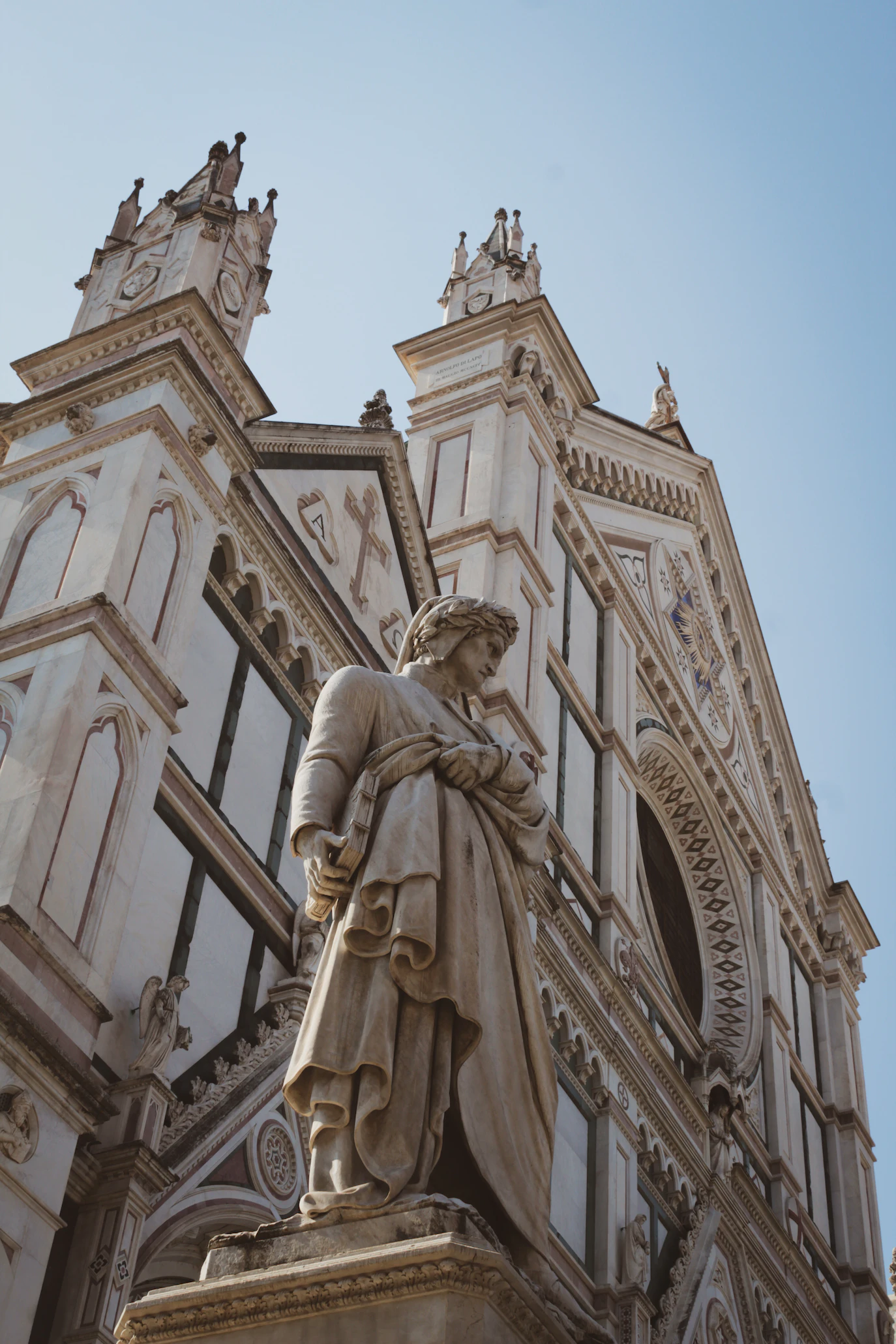 Statue of Dante in front of the Gothic facade of Santa Croce in Florence