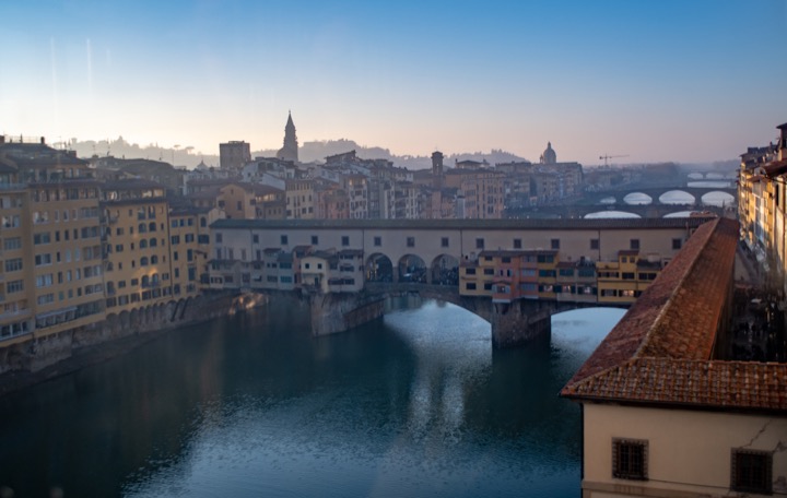 Ponte Vecchio and the Arno river at dusk with warm riverside buildings
