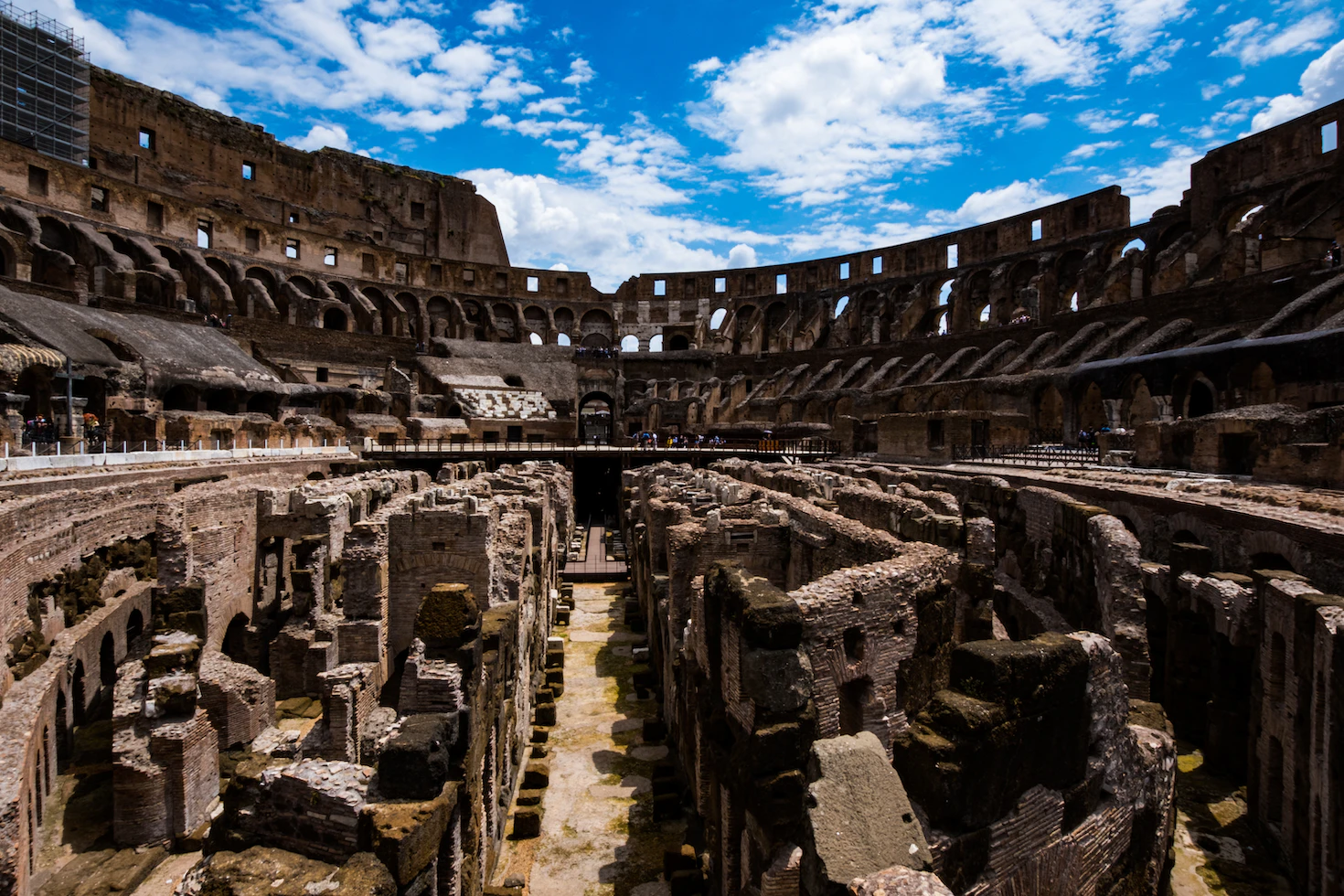Exposed underground chambers and passages of the Colosseum hypogeum below the arena, under a bright sky