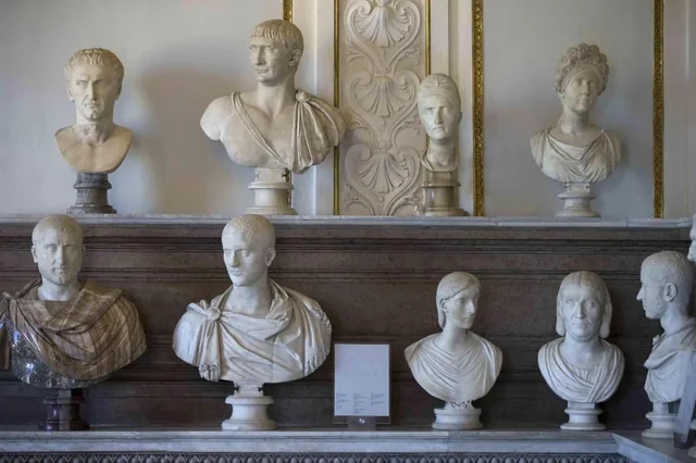 Shelves of white marble Roman portrait busts on pedestals in a museum room