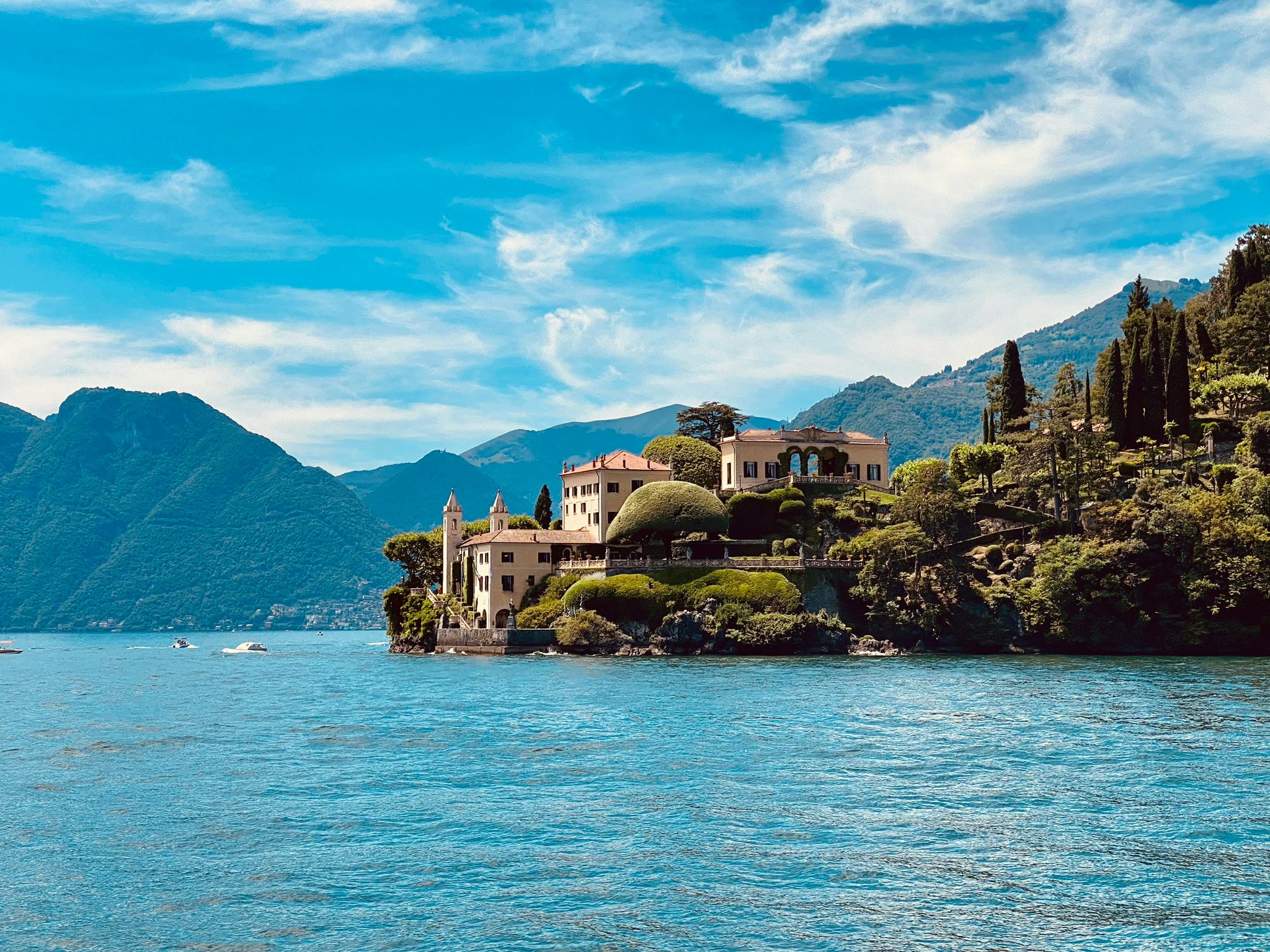 A villa on a wooded promontory above the blue water of Lake Como